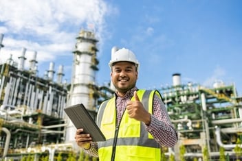 Man with thumb up with utility business behind