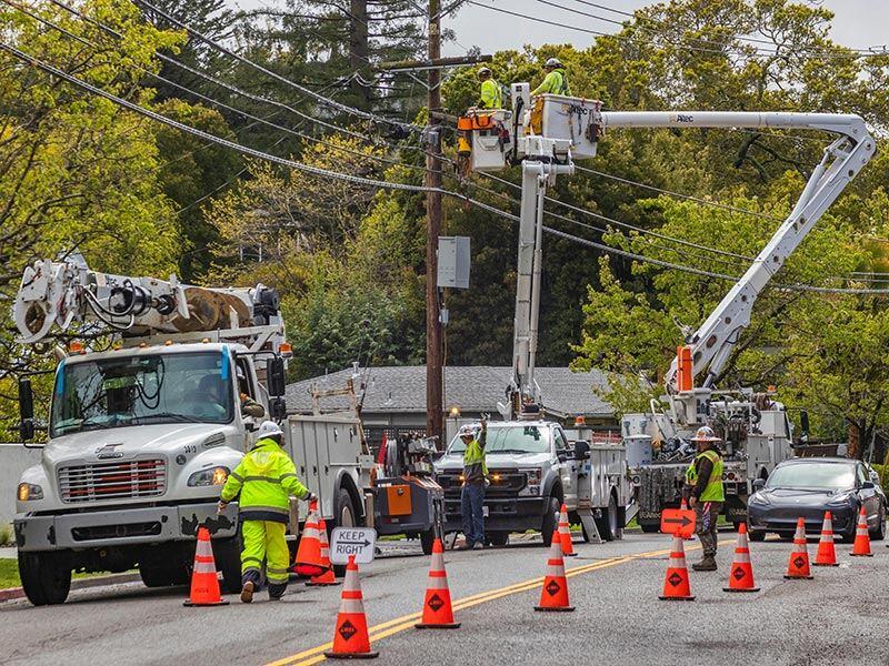 Workers blocking a road whilst fixing telegraph poles